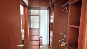 Un pasillo estrecho con armarios de madera y un perchero metálico.