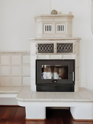 Ein weißer Kamin mit modernem Design, ein Sims mit dekorativen Elementen und ein eingelassener Fernseher.