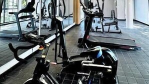 Un gimnasio con equipo de ejercicio, ventanas amplias y un diseño moderno del techo.
