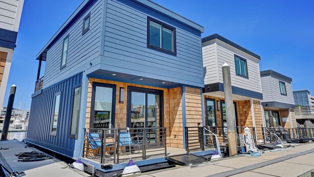 A modern two-story building with large windows and a balcony. - Modern 3BR Waterfront Houseboat | Walk to Wilmington Riverwalk and Dining (Wilmington)