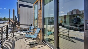 A modern building with large windows, a wooden deck, and outdoor seating. - Modern 3BR Waterfront Houseboat | Walk to Wilmington Riverwalk and Dining (Wilmington)