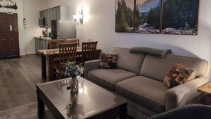Una sala de estar con sofá, mesa de centro y comedor con sillas y una mesa.