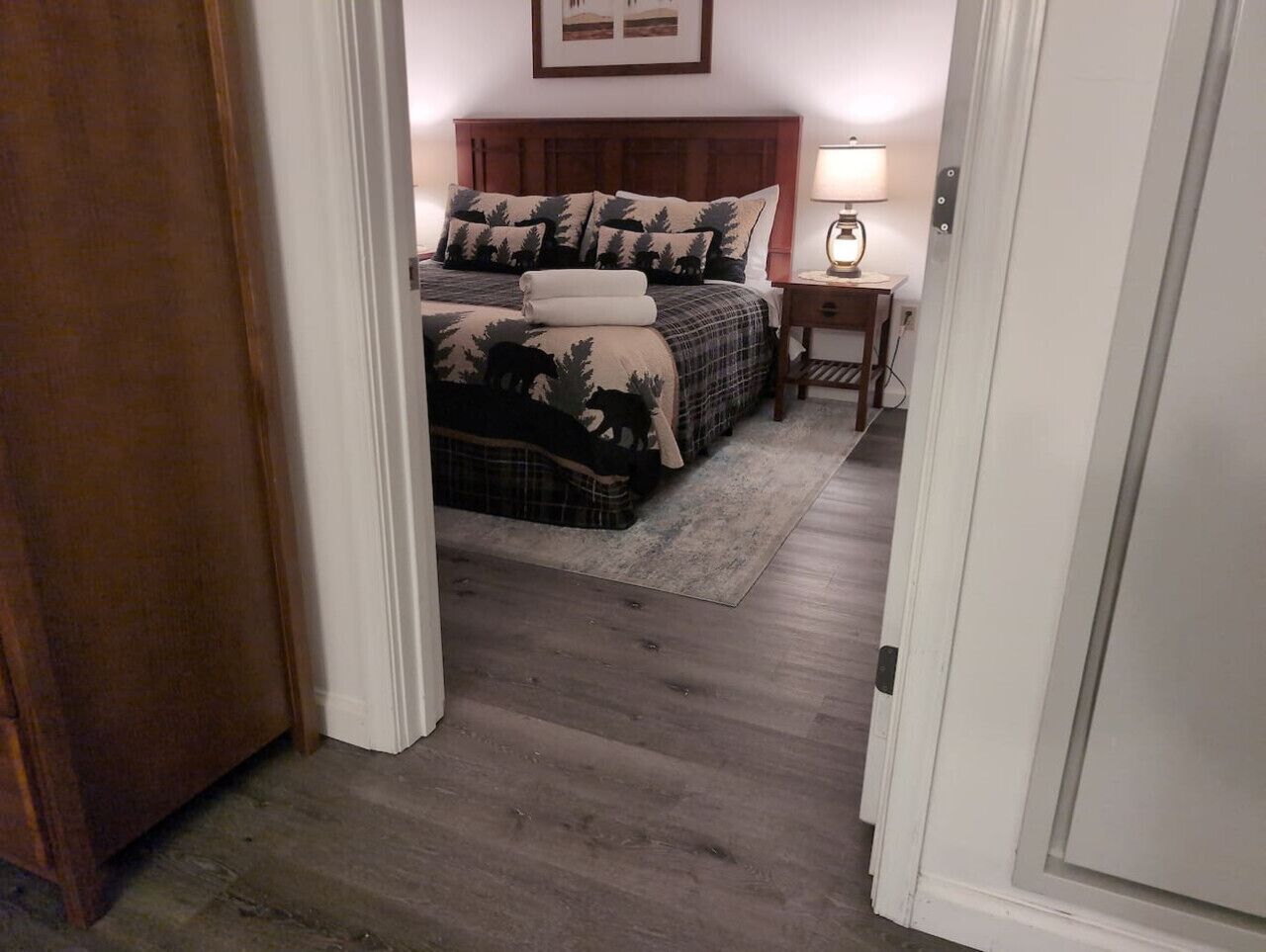 Un dormitorio con cama, mesita de noche y lámpara.