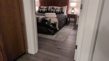 Un dormitorio con cama, mesita de noche y lámpara.