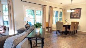 A living room with a sofa, a dining table with chairs, and a potted plant. - Spacious 3 bed 2 bath Sanctuary (Vernon Township)