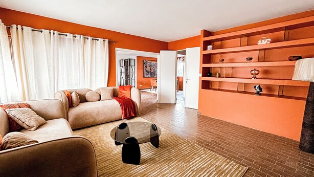 A living room with a sofa, a coffee table, and a bookshelf.
