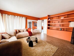 Ein Wohnzimmer mit einer Couch, einem Couchtisch und einem Bücherregal.