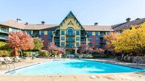 A hotel with a swimming pool, a large building with a distinctive triangular roof, and autumn-colored trees. - Lodge style getaway 50 miles from NYC patio 207 (Vernon Township)
