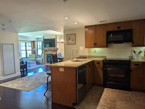 A modern kitchen with wooden cabinets, a built-in microwave, and an oven.