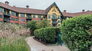 Ein Gebäude mit großem 'A' auf der Fassade, umgeben von Grünflächen und einem Weg.
