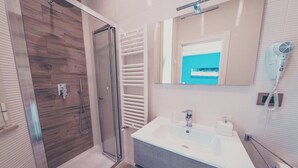 A modern bathroom with a glass shower enclosure, a large sink with a mirror, and a hairdryer mounted on the wall. - Cozy B&B,right in the center & within walking distance of beautiful sea of Gaeta (Gaeta)