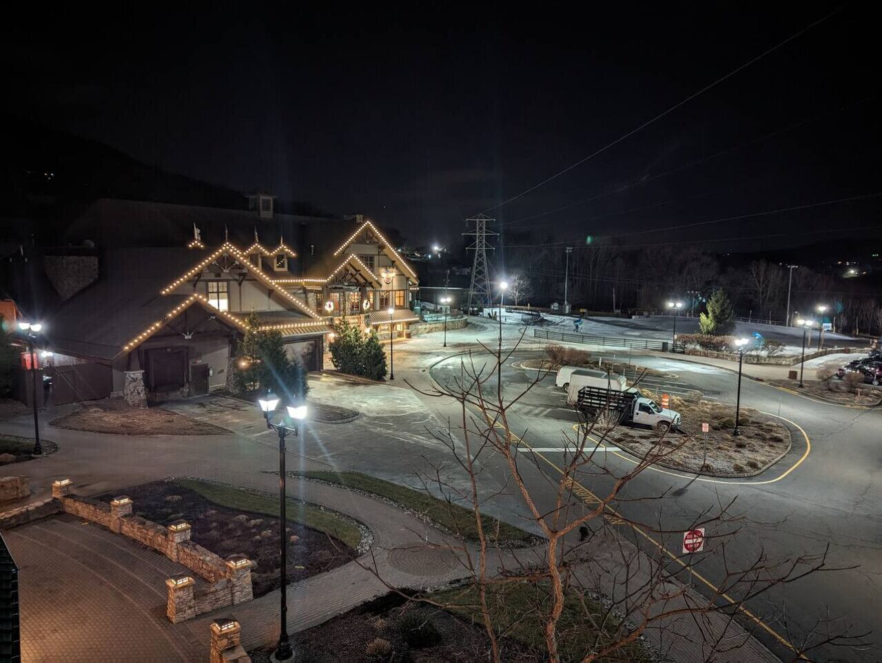 A well-lit building with a driveway and parking area.