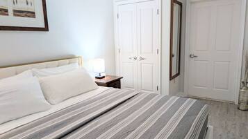 Ein Schlafzimmer mit einem Bett, einem Nachttisch und zwei weißen Türen.