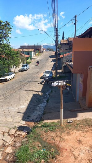 Una calle con edificios, una motocicleta y coches estacionados.
