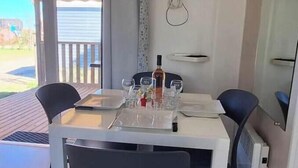 En matplats med ett bord dukat för två personer, en flaska vin och en tv som är monterad på väggen.