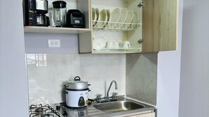 A compact kitchen with a gas stove, a slow cooker, a sink, and a dish rack. - Central studio apartment in Santa Rosa De Cabal (Santa Rosa de Cabal)