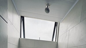 A small, tiled bathroom with a shower, a window, and a towel rack. - Central studio apartment in Santa Rosa De Cabal (Santa Rosa de Cabal)