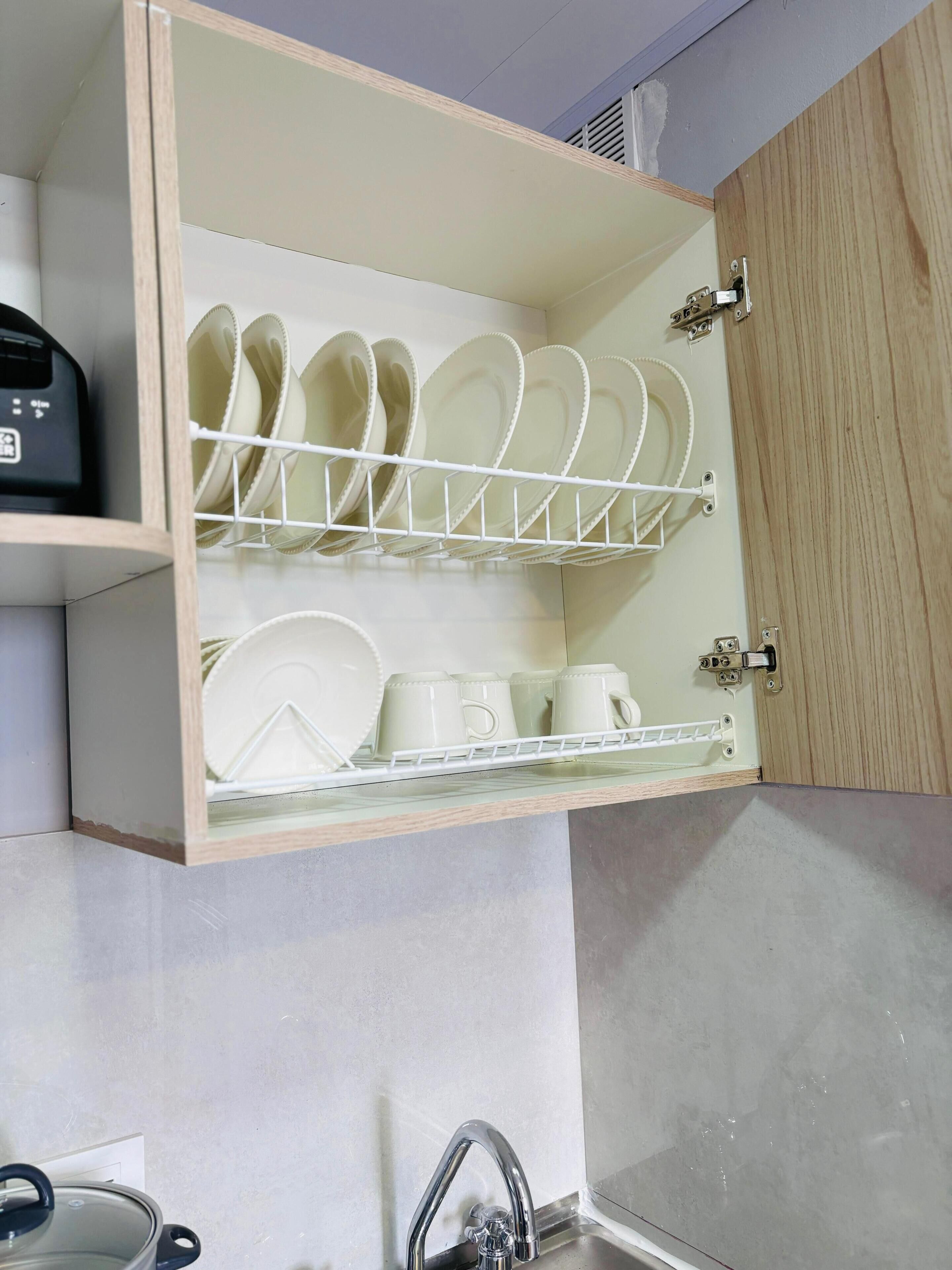 A kitchen with a dish rack, a coffee maker, and a sink.