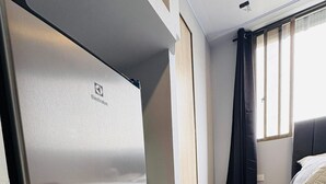 A modern hotel room with a large bed, a built-in wardrobe, and a window with curtains. - Central studio apartment in Santa Rosa De Cabal (Santa Rosa de Cabal)