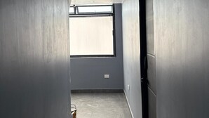 A narrow hallway with grey walls, a window at the end, and a door on the right. - Central studio apartment in Santa Rosa De Cabal (Santa Rosa de Cabal)