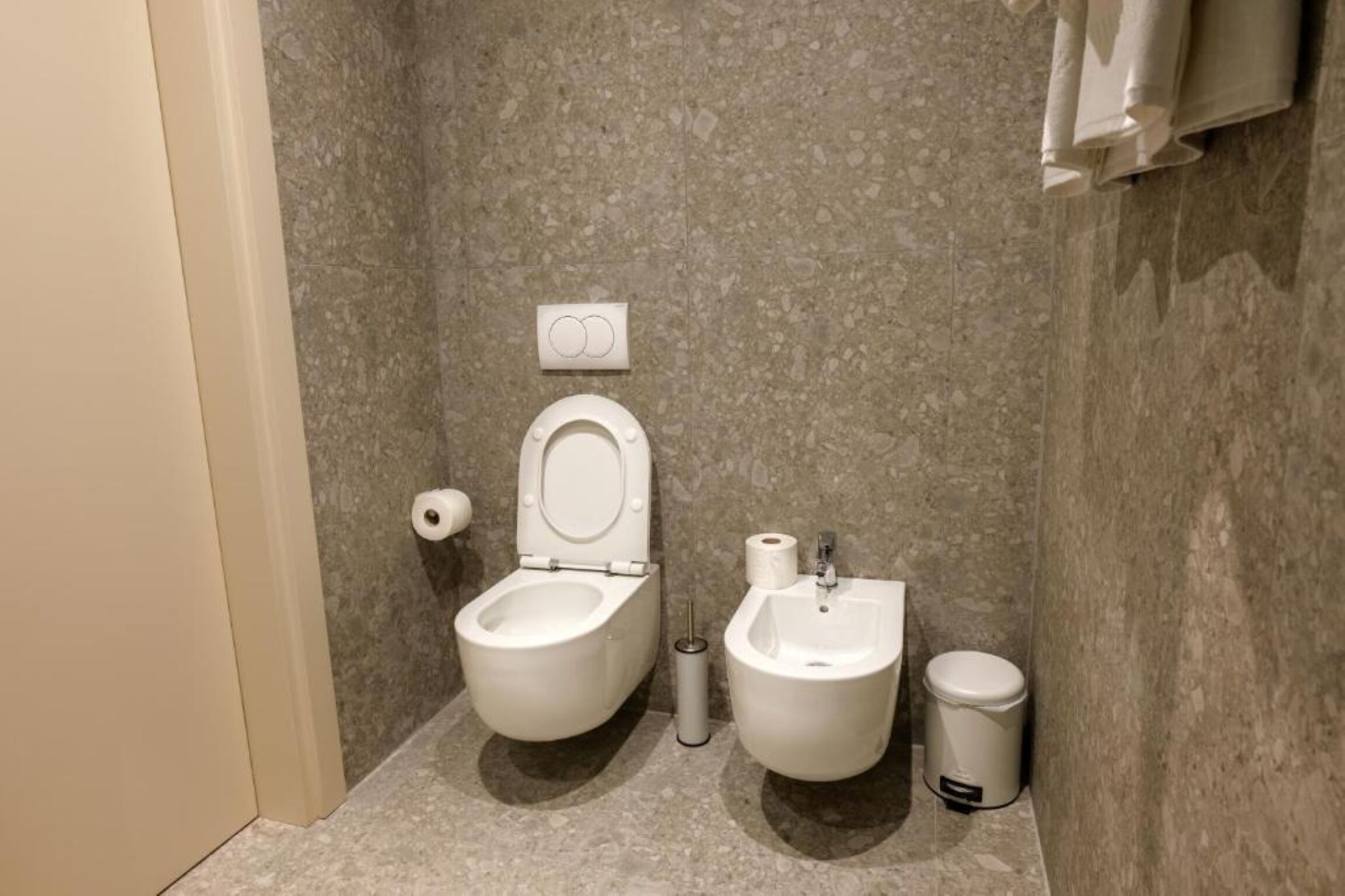 Ein kleines Badezimmer mit Toilette, Bidet und Mülleimer.