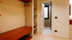 A hallway with a wooden bench, a hanging coat rack, and a door leading to another room. - Pusi Hotel (Tirana)