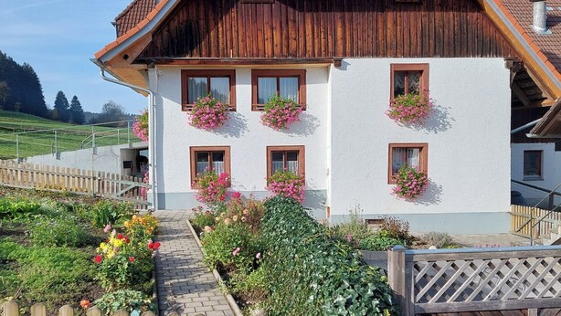 A traditional chalet with a sloped roof, wooden exterior, and flower boxes on the windows. - Haus Gloriosa: Where Black Forest tradition meets pure relaxation. (Bonndorf im Schwarzwald)