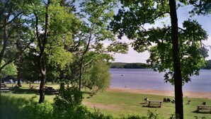 Un parc au bord du lac, équipé de tables de pique-nique et de bancs.