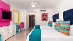 Ein Schlafzimmer mit Bett, Schreibtisch, Stuhl, Fernseher und einer Tür.