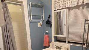 Une salle de bain équipée d’une douche, de toilettes, d’un lavabo et d’un porte-serviettes.