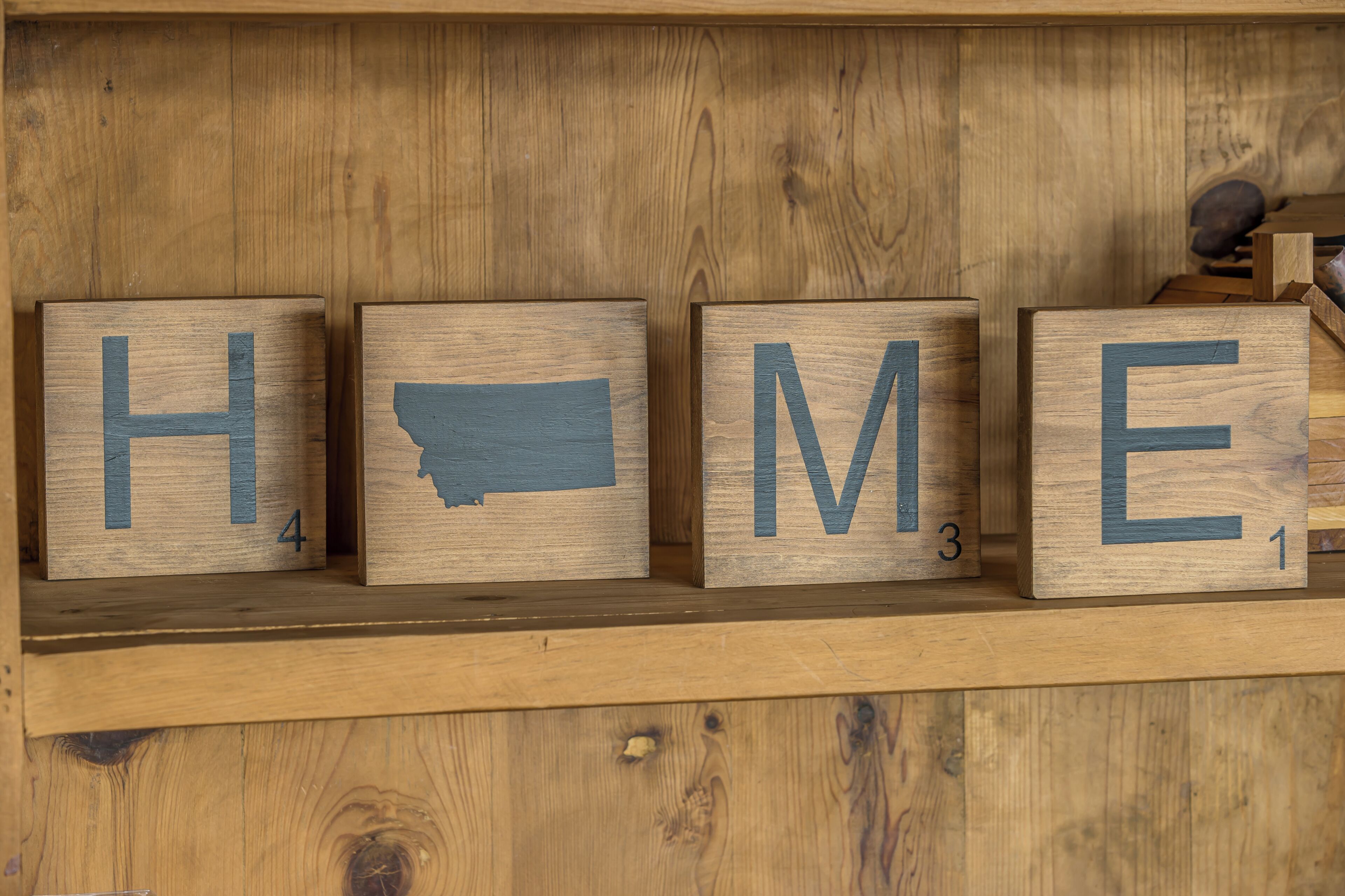 Wooden blocks spelling 'HOME' with numbers 1-4 on a shelf.
