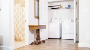 A small laundry area with a washing machine, a dryer, and a sink.