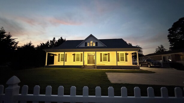 A two-story house with a front porch, a garage, and a driveway.