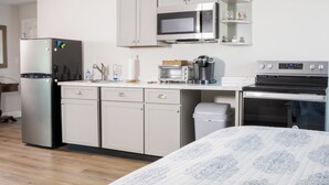 A compact kitchen with a refrigerator, microwave, toaster, coffee maker, and oven.