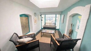 A room with a skylight, a sofa, two chairs, a coffee table, and a view through a window. - Charming house in the heart of L'Aiguillon-sur-mer - 8 people (L'Aiguillon-la-Presqu'île)
