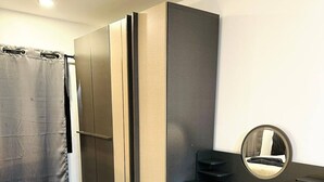 A modern bedroom with a wardrobe, a desk, and a mirror. - Smart Studio Appartment Near Old Town Phuket (Phuket)