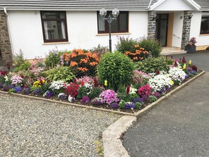 Une maison avec un jardin fleuri devant.