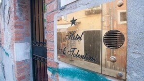 Ein Hotelschild mit dem Schriftzug 'Hotel Ai Tolentini' an einer Wand.