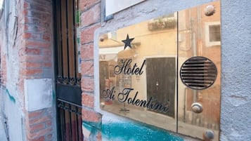 Ein Hotelschild mit dem Schriftzug 'Hotel Ai Tolentini' an einer Wand.