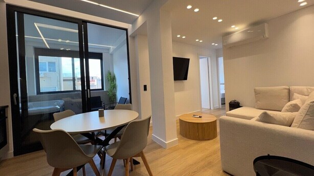 Een modern interieur met een ronde tafel, stoelen, een bank en een televisie.