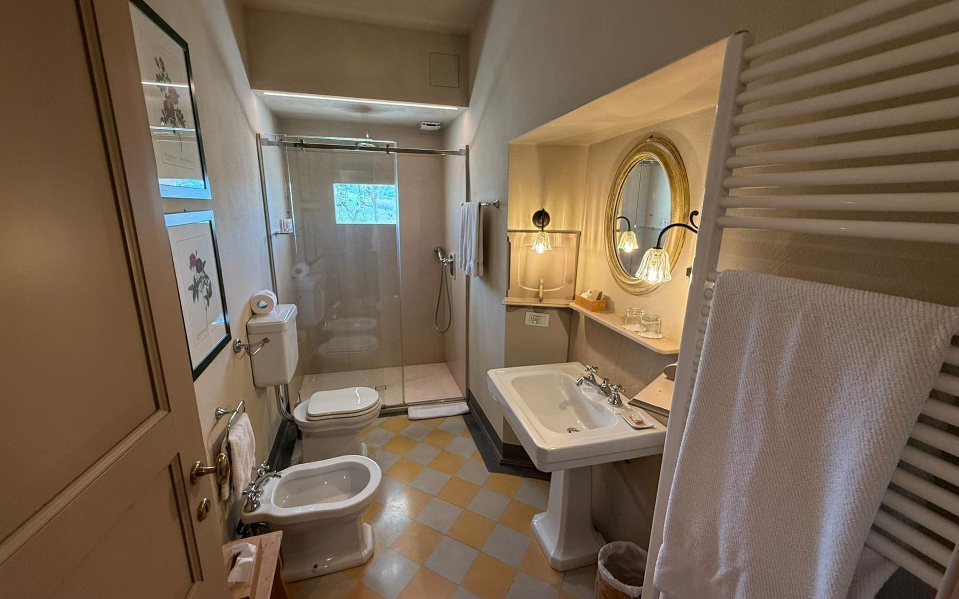A compact bathroom with a toilet, bidet, sink, and shower.