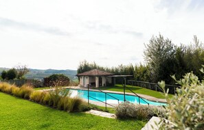 A swimming pool with a small pavilion, surrounded by a grassy lawn and trees. - Relais dei Poderi Einaudi (Dogliani)