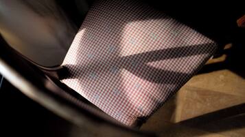 A close-up of a checkered fabric with a pattern, likely part of a chair or seat upholstery.