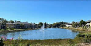 A pond with fountains, surrounded by buildings with a flat roof and large windows. - Update and Immaculate, 2 beds 2 baths end unit. On Imperial Golf Course (Naples)