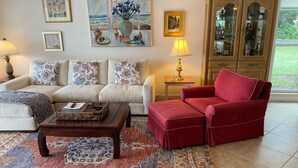 A living room with a sofa, armchair, coffee table, and patterned rug. - Update and Immaculate, 2 beds 2 baths end unit. On Imperial Golf Course (Naples)