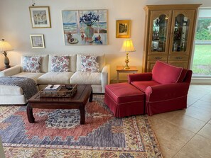 A living room with a sofa, armchair, coffee table, and patterned rug. - Update and Immaculate, 2 beds 2 baths end unit. On Imperial Golf Course (Naples)