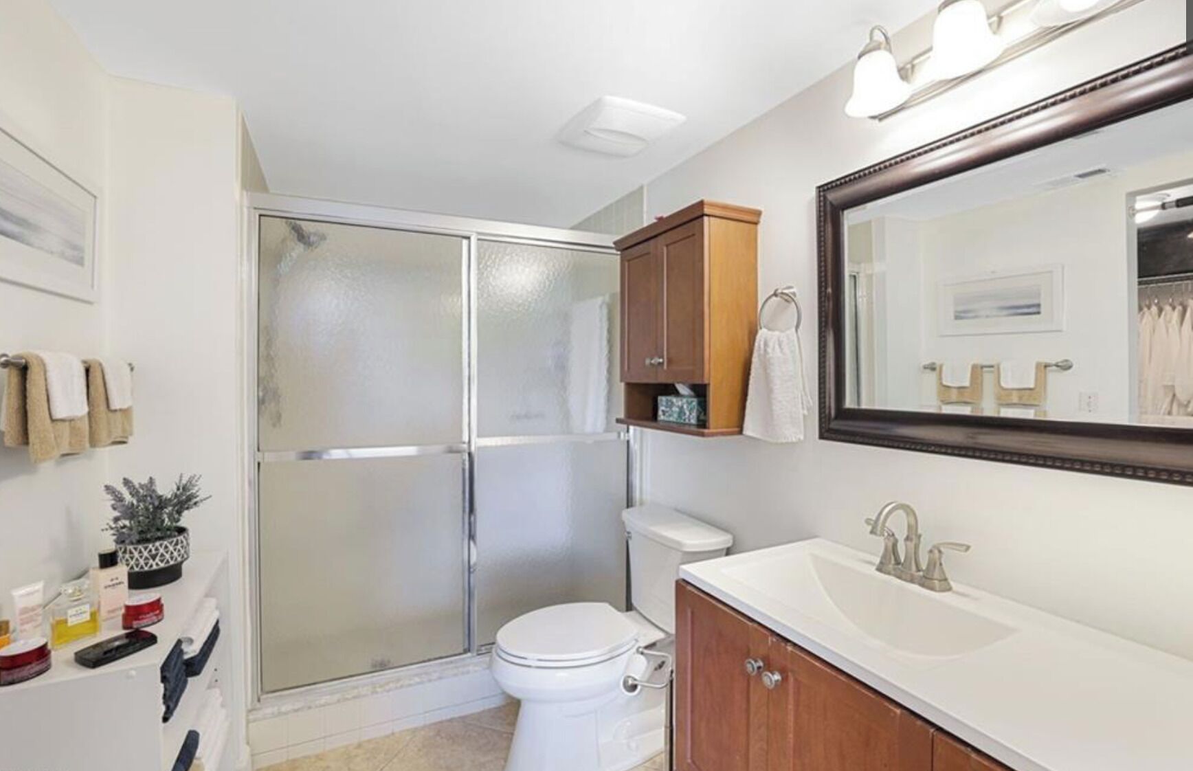Une salle de bain équipée d’une douche, de toilettes, d’un lavabo et d’un meuble de rangement.