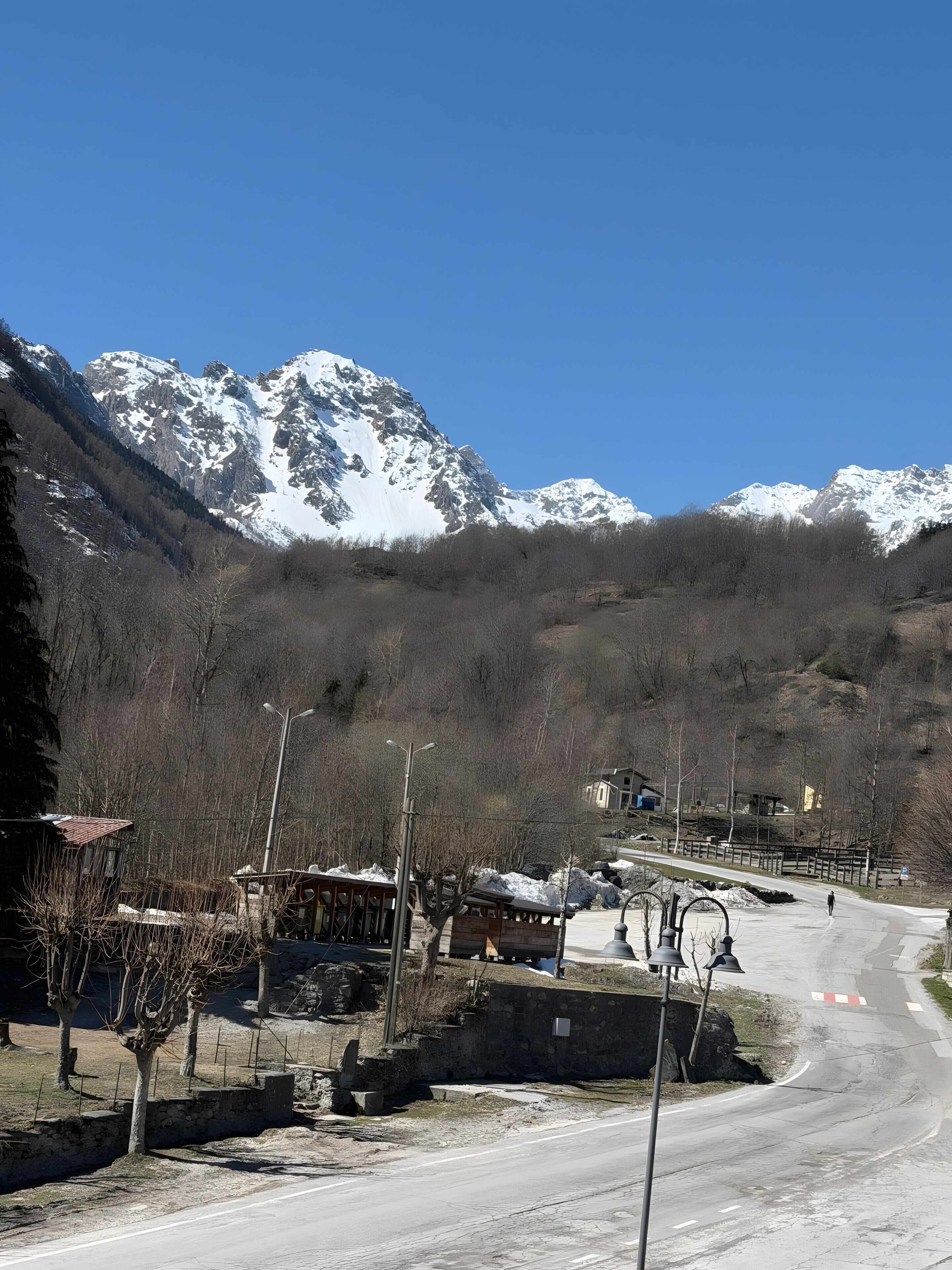 Un paysage montagneux avec une route menant à un petit village.
