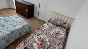 Ein Schlafzimmer mit zwei Betten, einem Schminktisch, einem Kleiderständer und einem Fenster mit Blick.