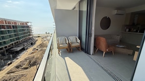 A balcony with a view of a construction site and the sea. - APTO MORROS KAI CON SALIDA AL MAR  (Cartagena)